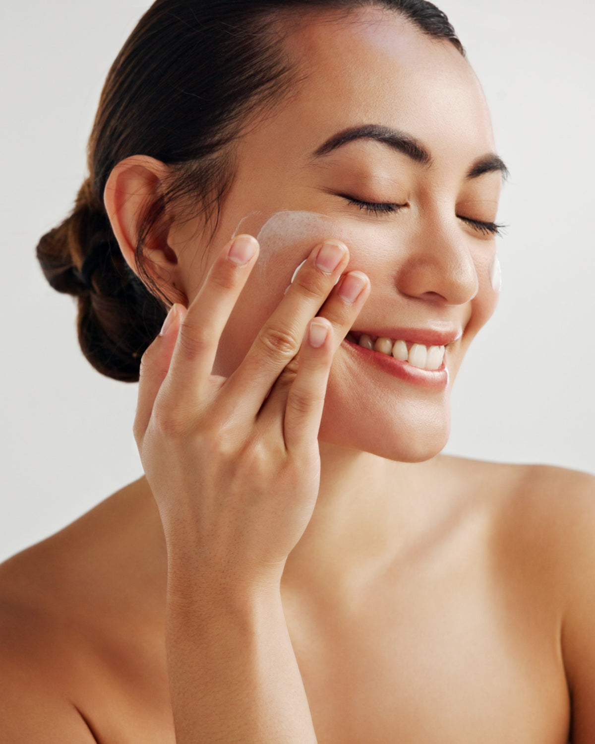 Woman applying Aminocare Reverse Face Cream with collagen in Houston, Texas