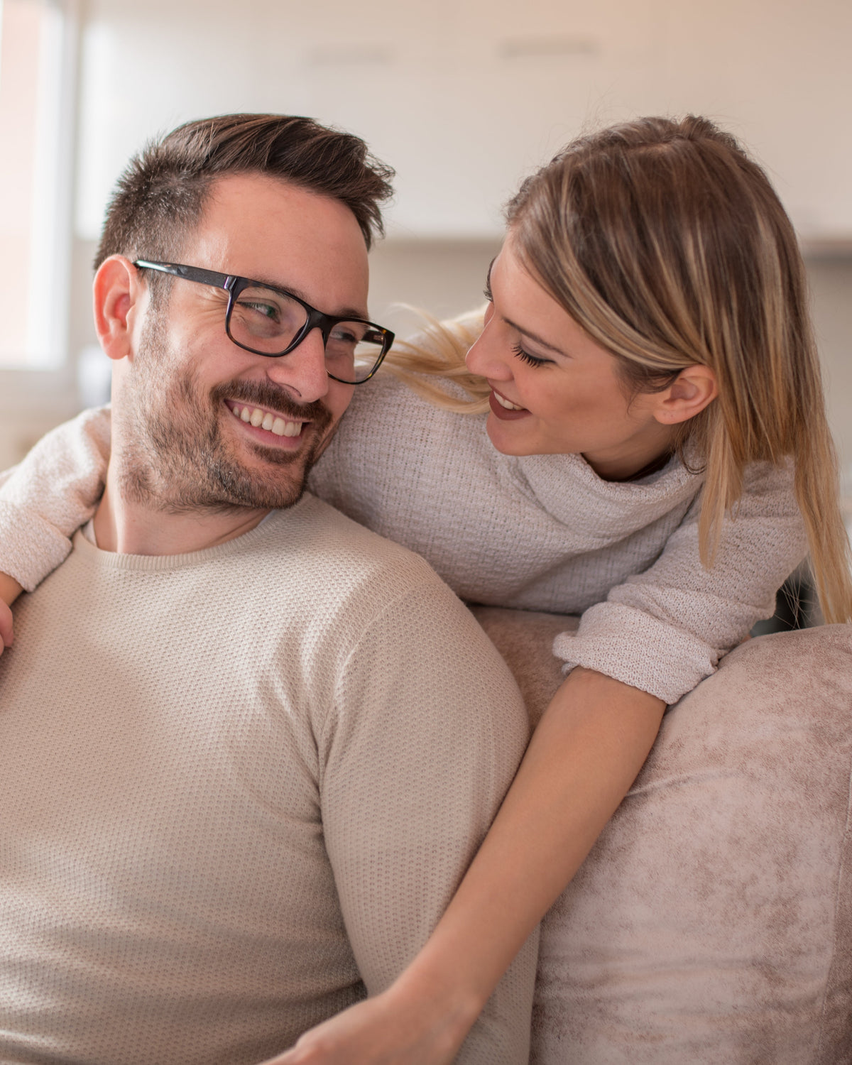 Couple relaxing at home smiling together, representing healthy lifestyle, wellness, and daily nutrition support by Aminocare®