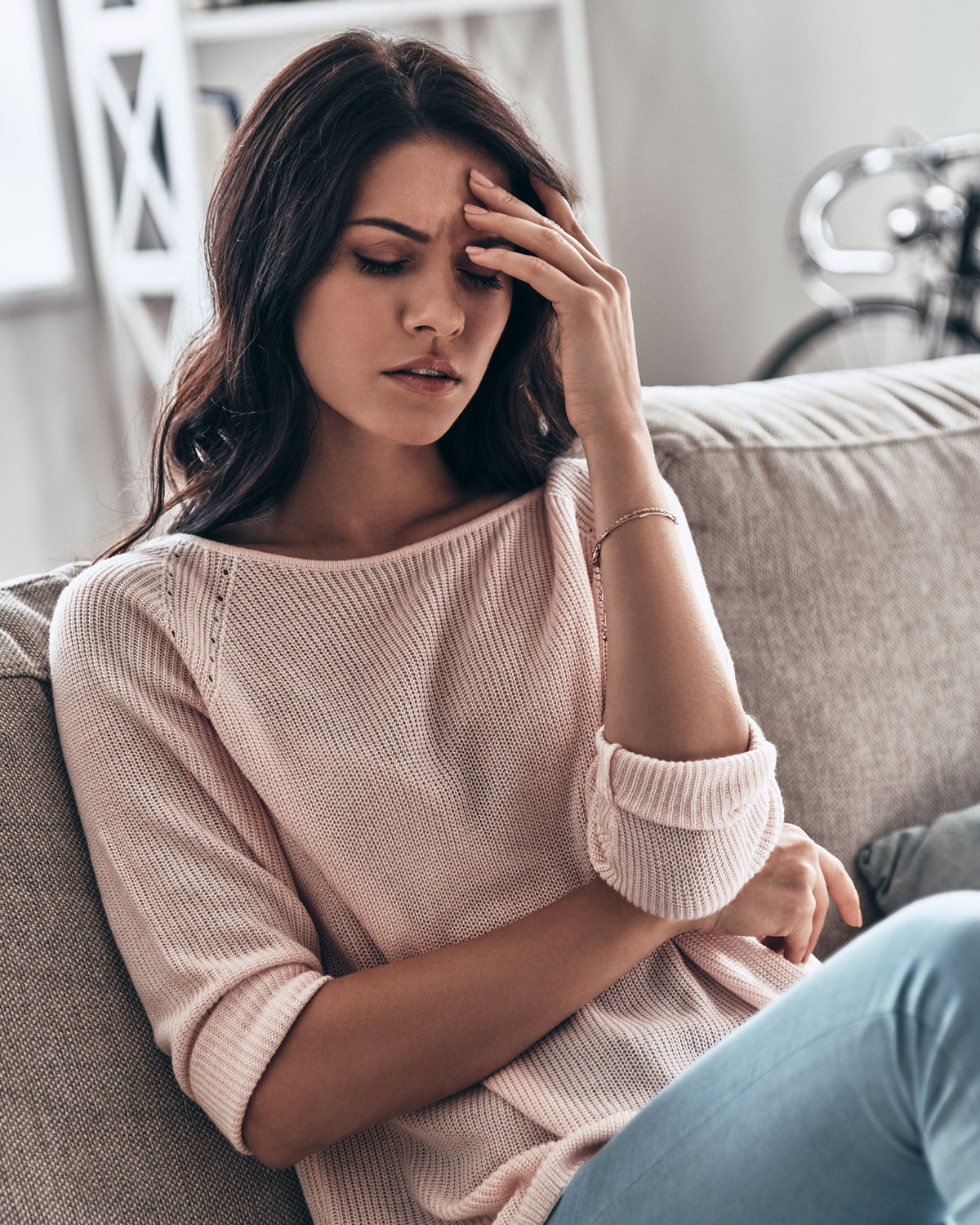 Tired woman holding her head showing fatigue linked to gut health and low energy, supported by AminoCare® Berberine
