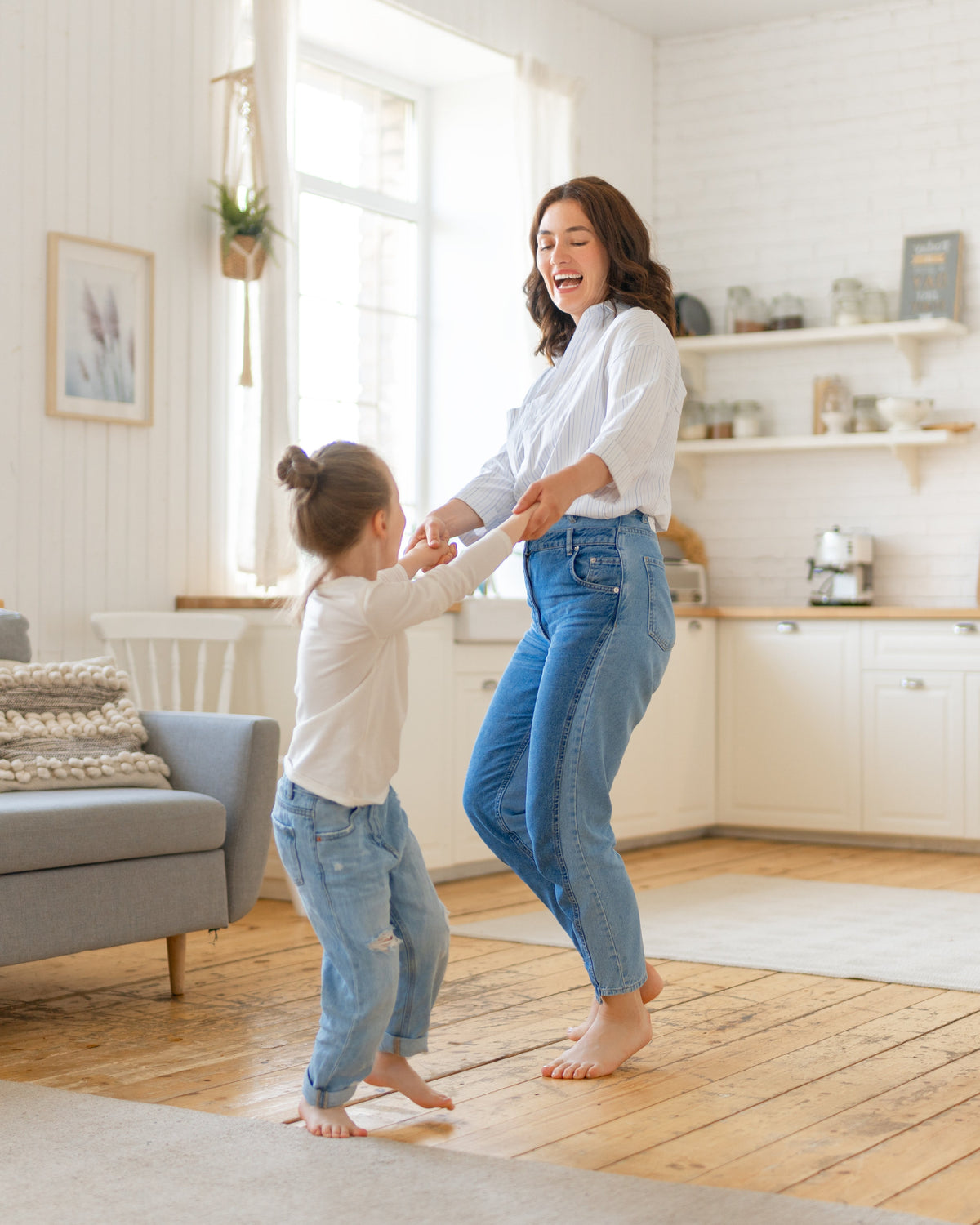 Mother and child playfully dancing in living room. Happy Mother's Day from Aminocare